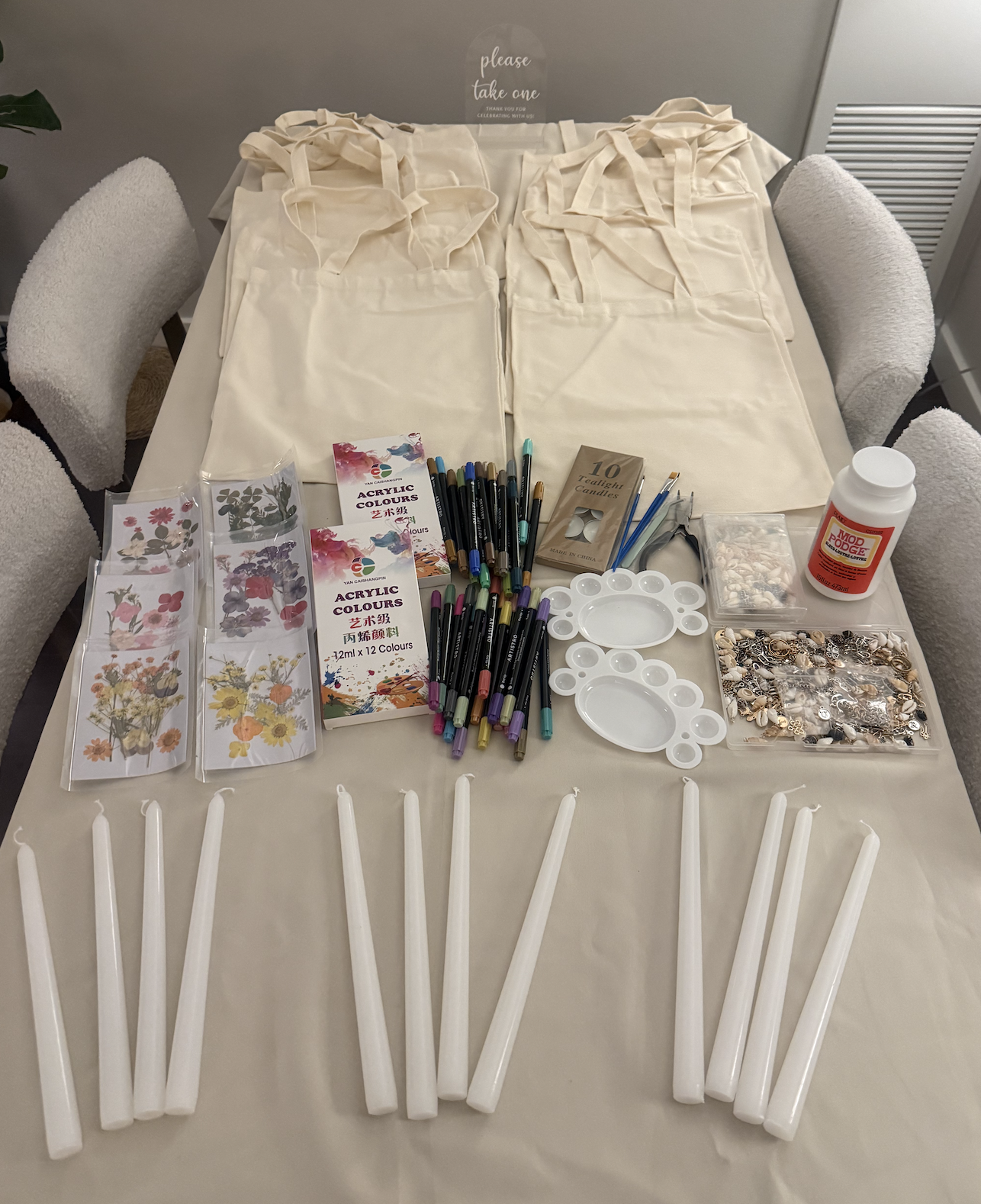 Creative craft event setup with tote bags, paints, and supplies